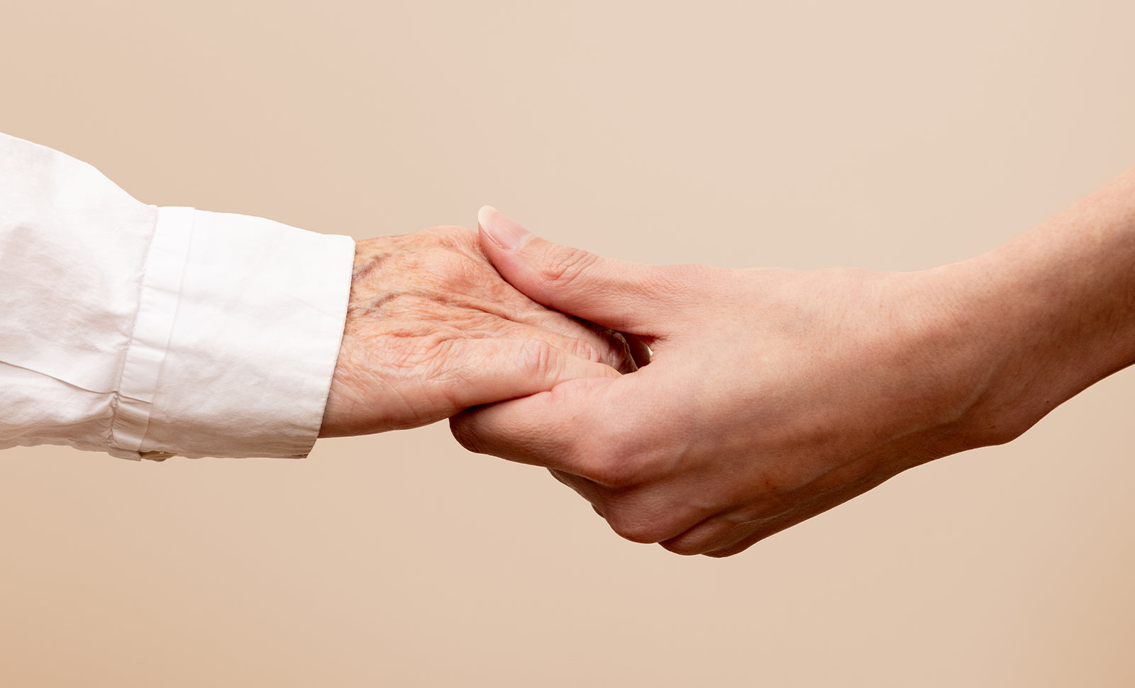 Two hands gently holding, one older and one younger
