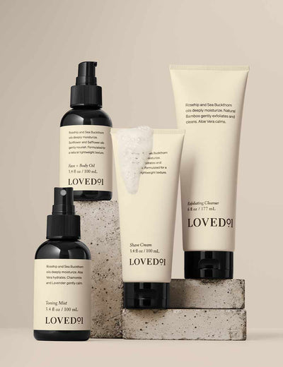 Product collection image with a tan background. The image shows the Exfoliating Cleanser, Face+Body Oil, Toning Mist, and Shave Cream. 
